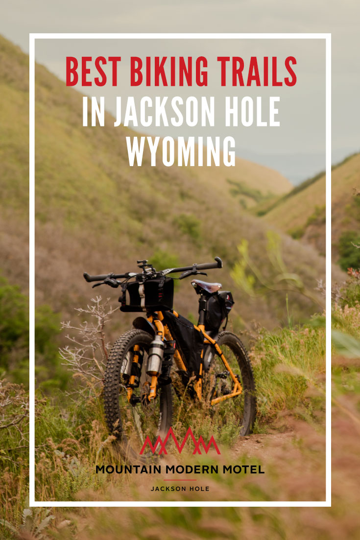 Bicycle on mountain trail. Overlay text reads: "Best Biking Trails in Jackson Hole, Wyoming."