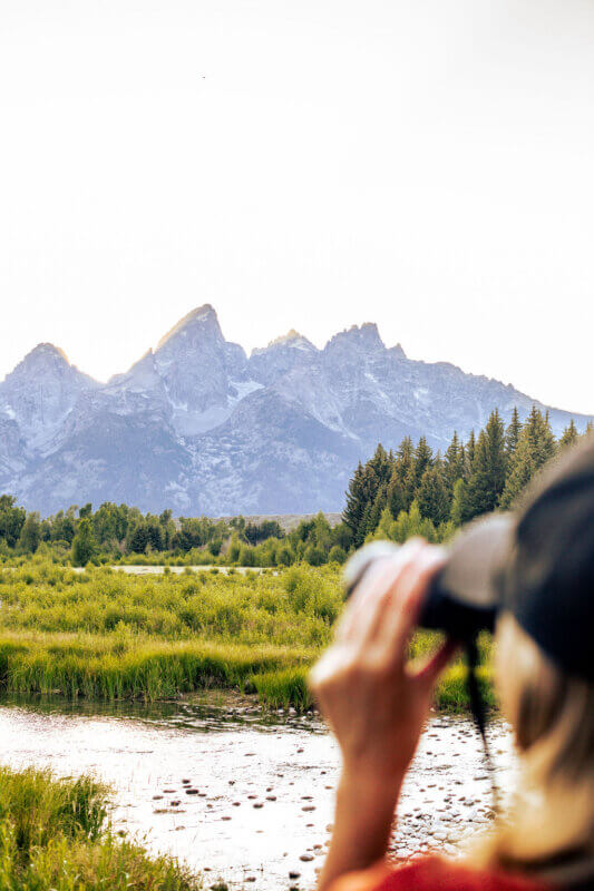Girl with binoculars sightseeing in Grand Teton National Park